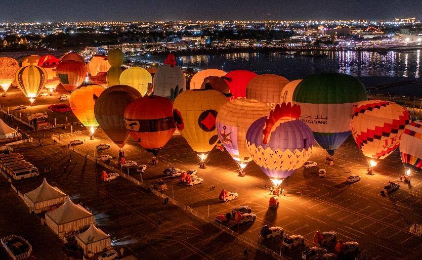Hot air balloons glowing at night at the Qatar Balloon Festival, Katara