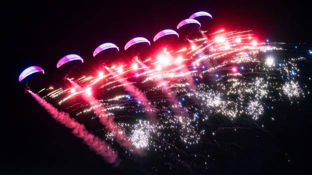 Skydivers trailing pyrotechnics over Lusail at night